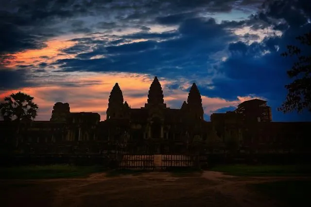 Angkor Wat al tramonto in silhouette Le torri di Angkor Wat in silhouette contro il cielo colorato del tramonto, parco archeologico di Angkor in Cambogia