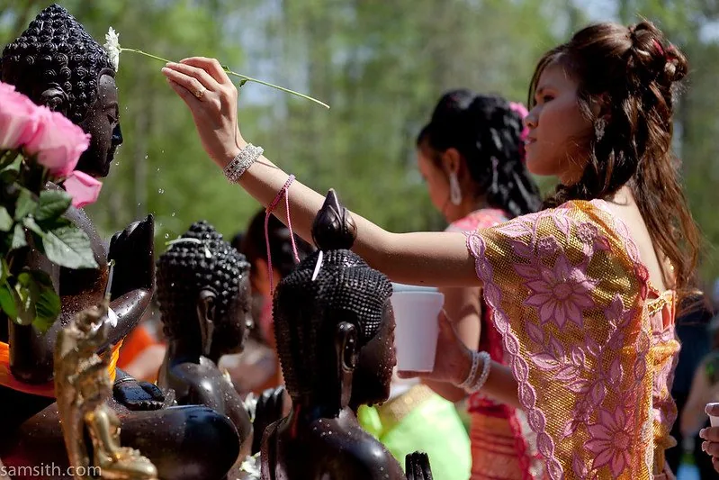 Ragazze versano un rigolo d'acqua sulle statue di Buddha per la cerimonia dell'acqua, durante il Capodanno Khmer Ragazze versano un rigolo d'acqua sulle statue di Buddha per la cerimonia dell'acqua, durante il Capodanno Khmer
