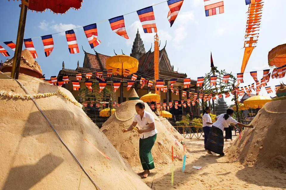 In un tempio delle donne infilano bastoncini di incenso nelle montagnette di sabbia costruite per il Capodanno buddhista In un tempio delle donne infilano bastoncini di incenso nelle montagnette di sabbia costruite per il Capodanno buddhista