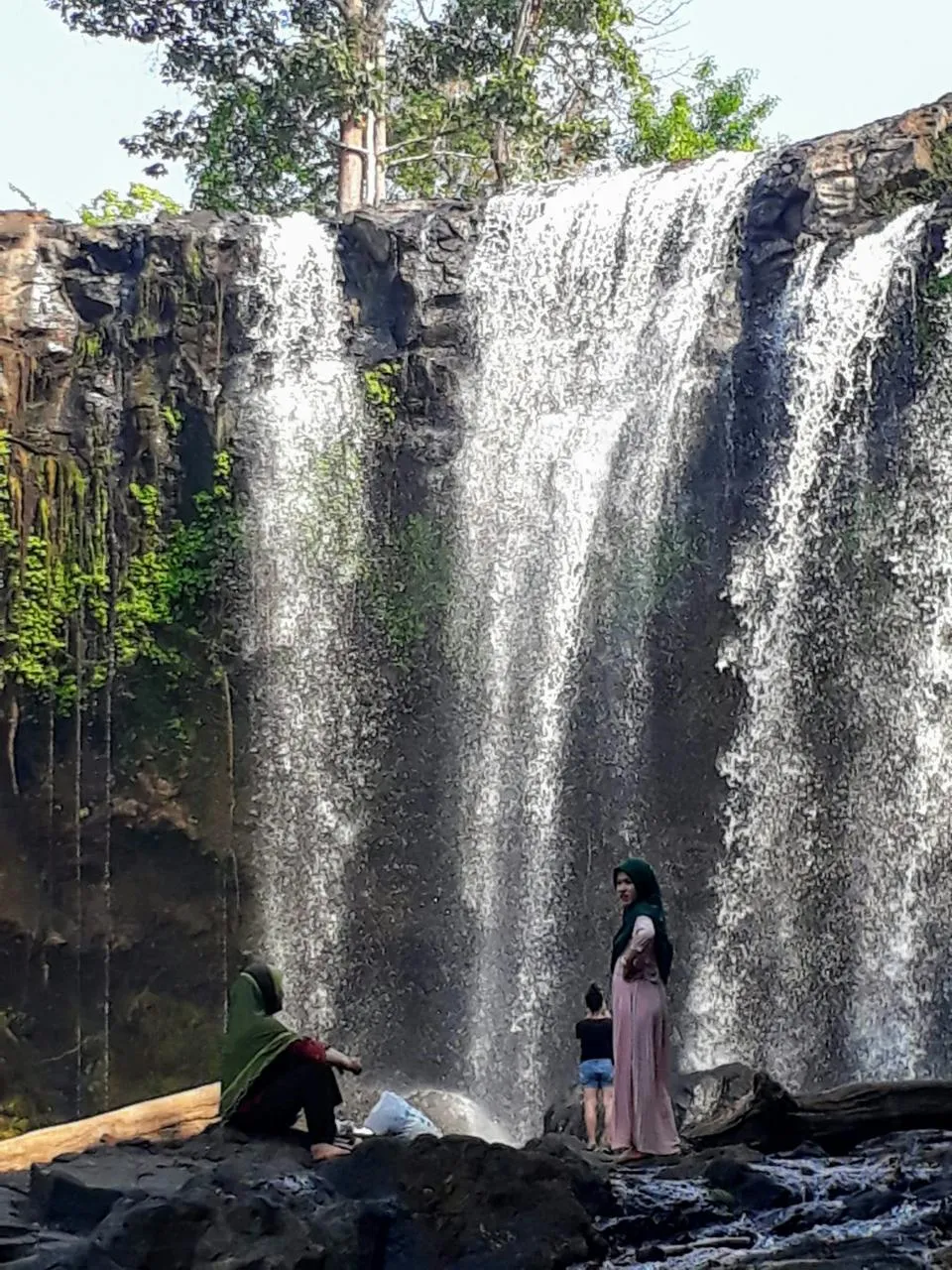 La cascata di Bou Sra con i visitatori I visitatori sulla roccia alla base della cascata di Bou Sra, nella provincia di Mondulkiri, Cambogia orientale