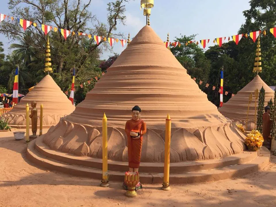 Colline di sabbia decorate con bandierine nel cortile di una pagoda durante il Capodanno khmer in Cambogia