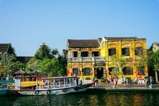 Un sampan sul fiume Thu Bon davanti alle facciate coloniali del centro storico di Hoi An in Vietnam, tappa dell'itinerario di due settimane tra Vietnam e Cambogia