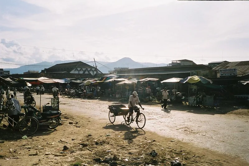 Una bicicletta attraversa una polverosa strada a Kampot