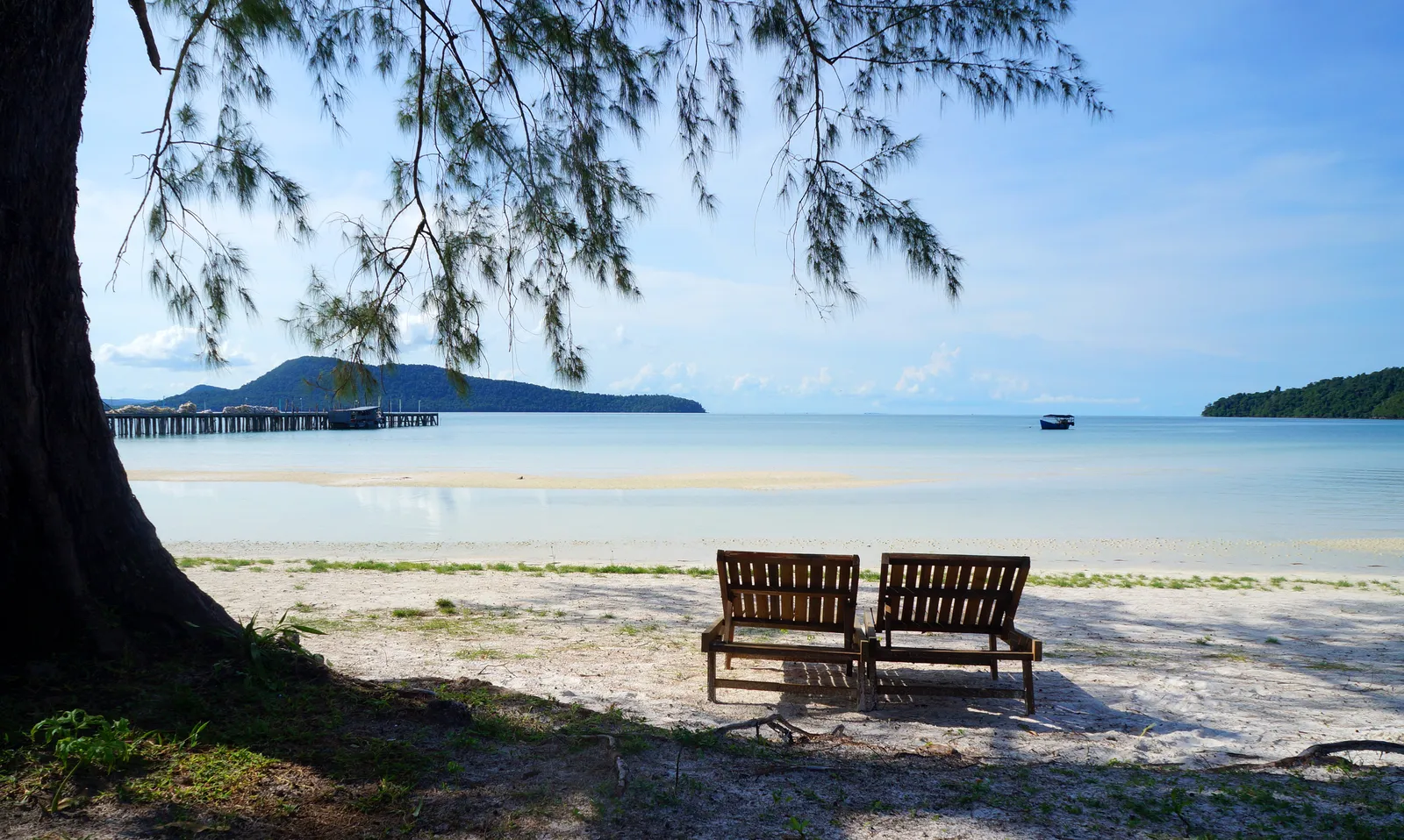 La quiete della spiaggia di Koh Rong Sanloem Sedie a sdraio in legno all'ombra di un albero sulla spiaggia di Koh Rong Sanloem, Cambogia