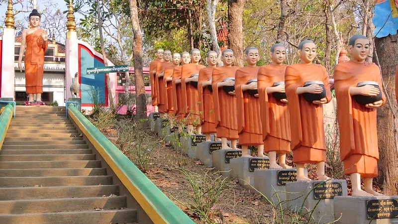 Statue di monaci sulla scalinata che sale verso la pagoda Phnom Sambok