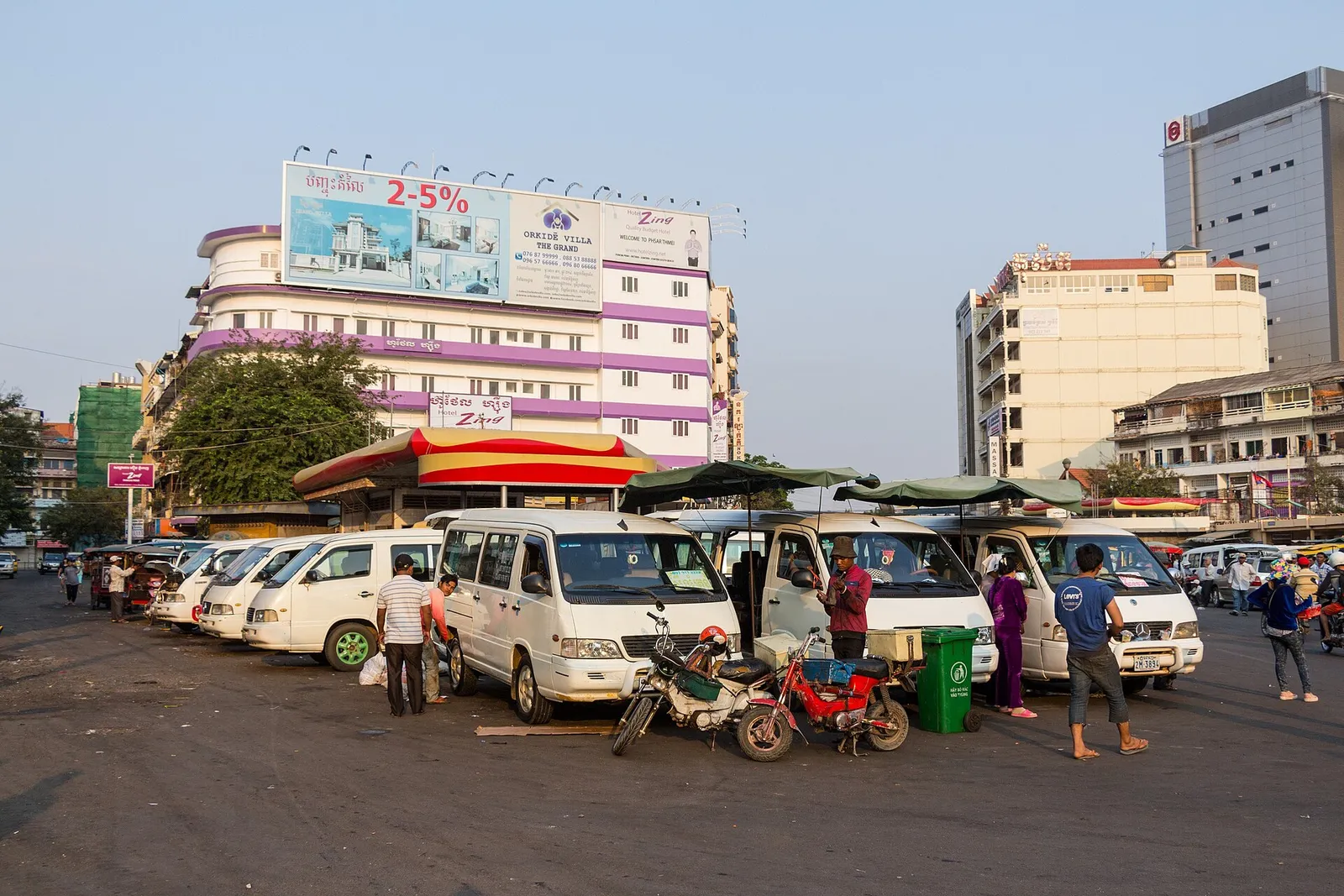La stazione dei minivan di Phnom Penh Stazione dei minivan a Phnom Penh con van bianchi in attesa di passeggeri per le tratte in Cambogia
