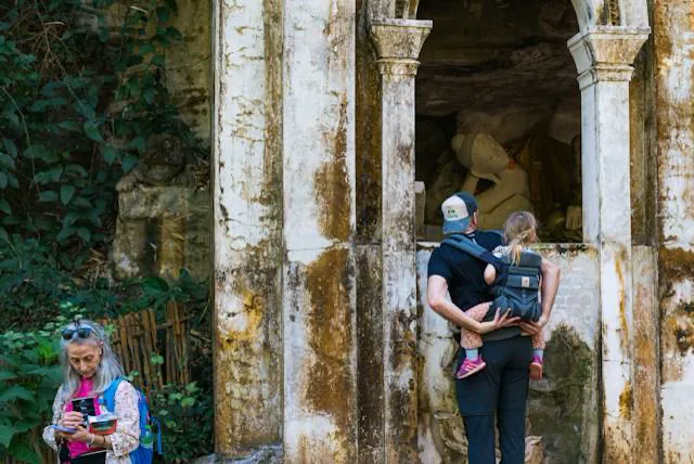 Un padre con la figlia nel marsupio davanti ad un santuario khmer Un padre con la figlia nel marsupio davanti ad un antico santuario khmer, durante un viaggio in Cambogia con bambini