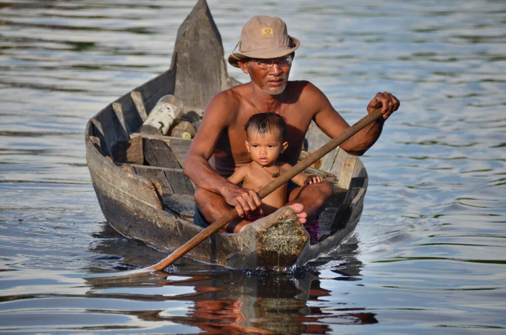 padre e figlio in una piccola barca in legno
