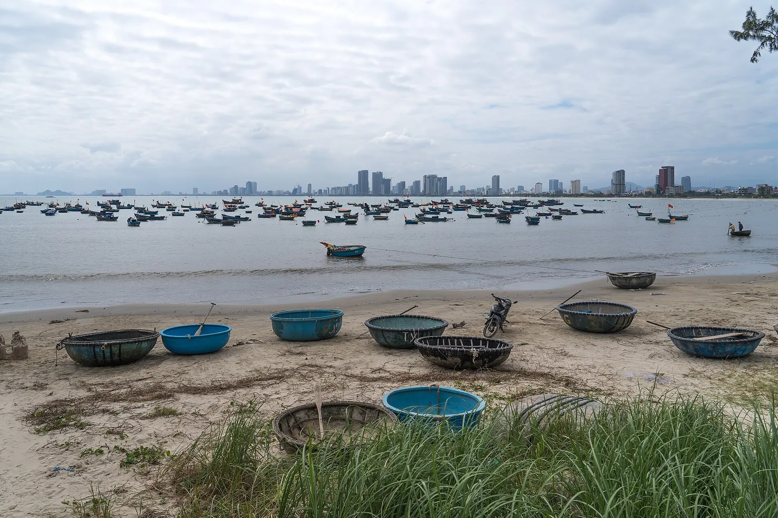 La costa di Da Nang in Vietnam La spiaggia di Tho Quang con i tipici coracle e lo skyline di Da Nang, in Vietnam