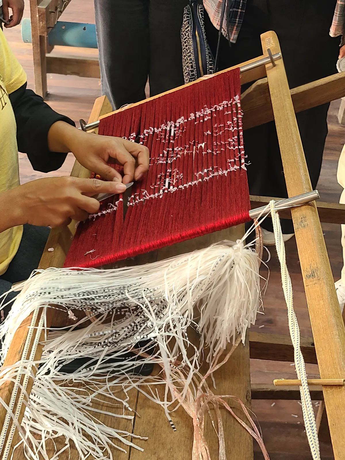 I fili legati per l'ikat Tecnica ikat khmer: artigiana che lega i fili di seta per la tintura a riserva nell'atelier di Artisans Angkor