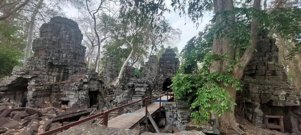 Torre con volti di pietra e passerella di legno nel tempio satellite Ta Prohm a Banteay Chhmar, nel nord-ovest della Cambogia