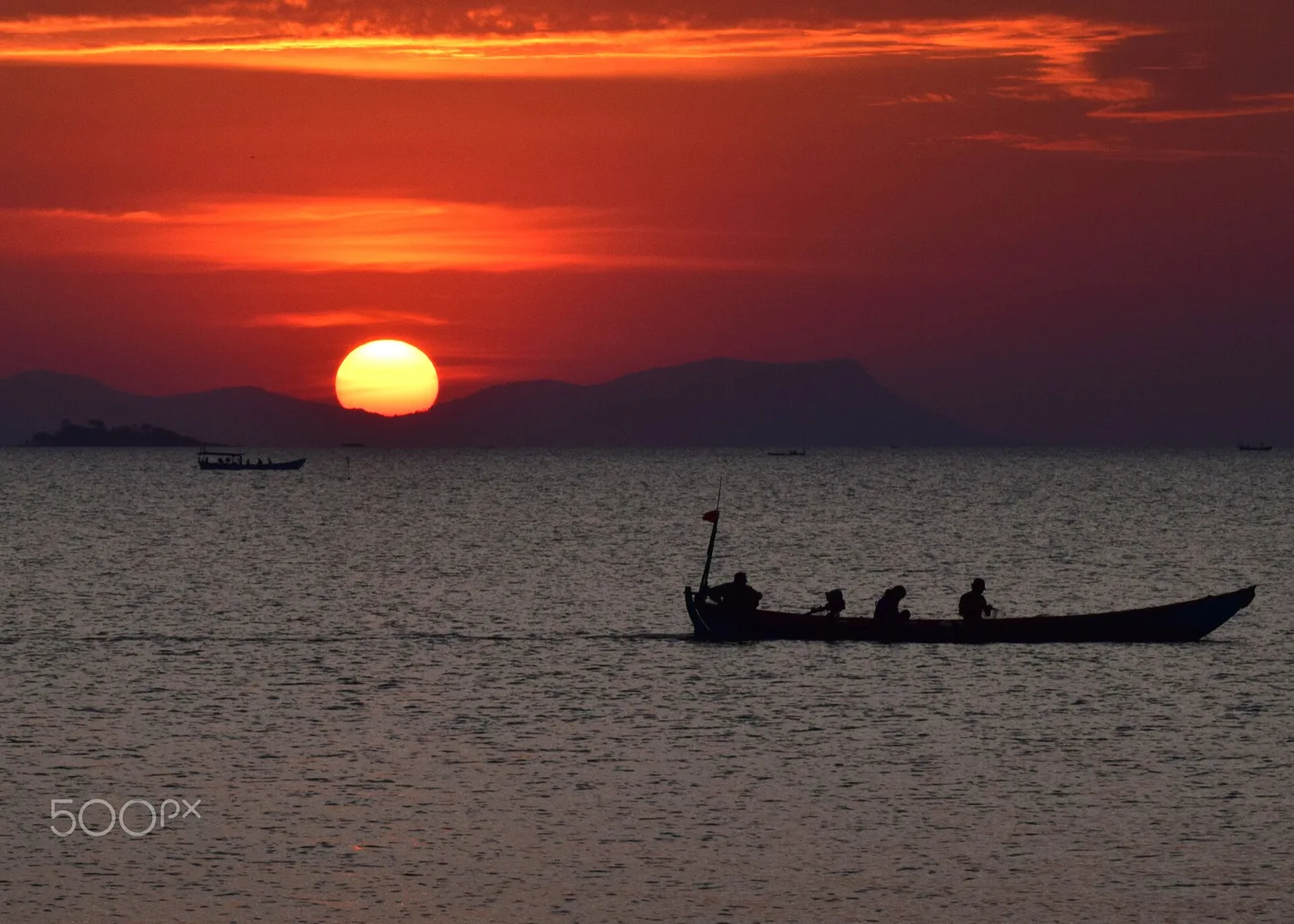 Tramonto sul Golfo della Thailandia con una barca di pescatori al largo di Kep, in Cambogia