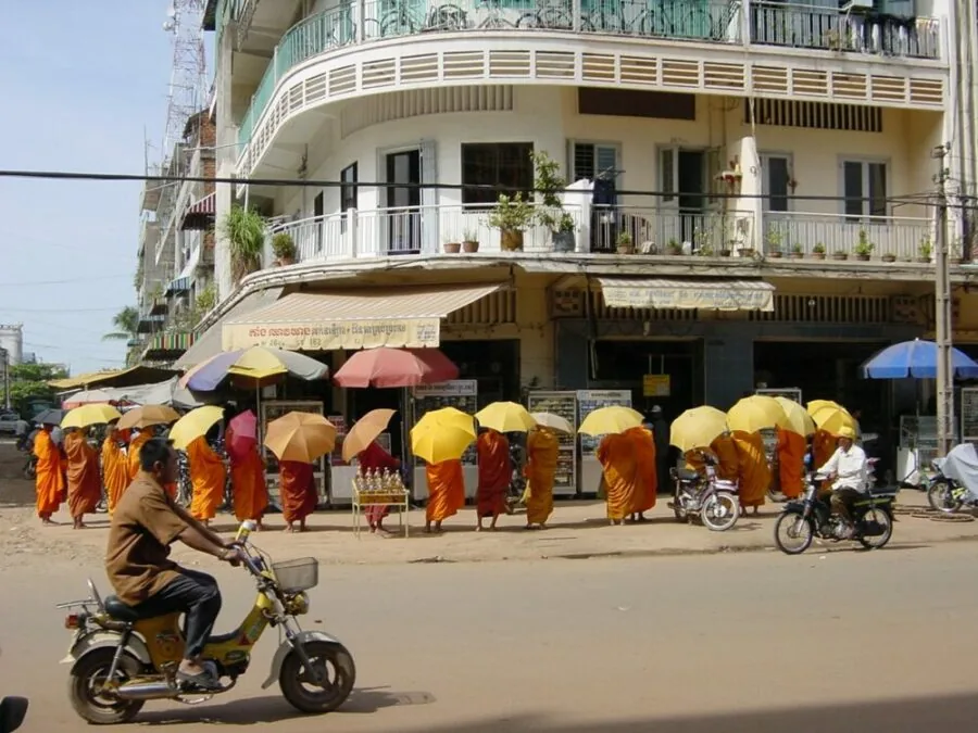Monaci a Phnom Penh, cuore pulsante del Paese un gruppo di monaci in abiti arancioni e ombrelli gialli in giro per Phnom Penh
