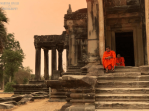monaco seduto sui gradini di un tempio al tramonto, Angkor