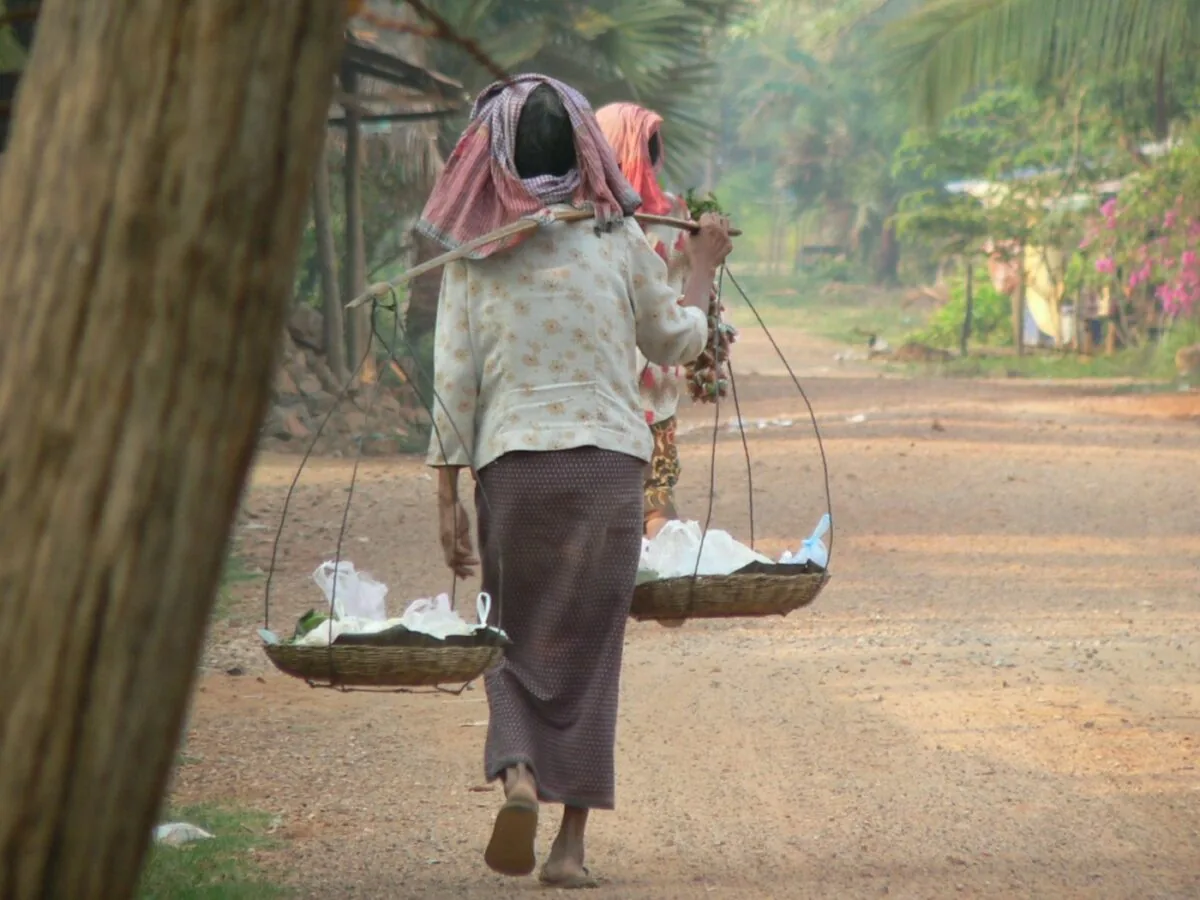 nord-est della Cambogia: Mondulkiri, tra montagne e foreste venditrice ambulante si allontana di spalle con la sua mercanzia