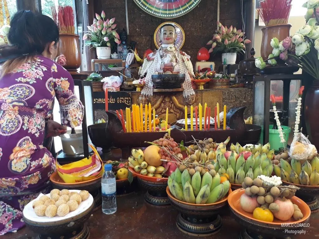 statua della signora Penh con offerte e candele al Wat Phnom