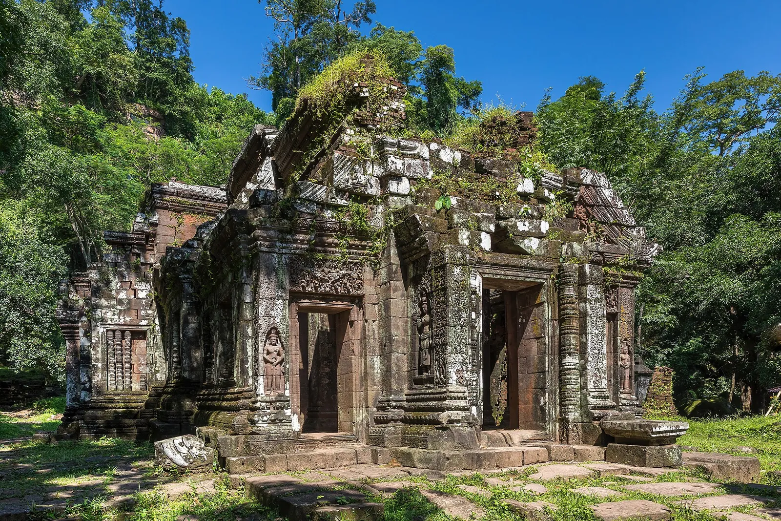 Il tempio khmer di Wat Phou a Champasak in Laos, santuario di pietra coperto di muschio con bassorilievi e statue del Buddha, tappa del viaggio combinato tra Laos e Cambogia